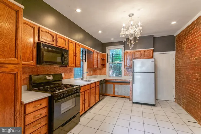 a kitchen with granite countertop a refrigerator and a stove top oven