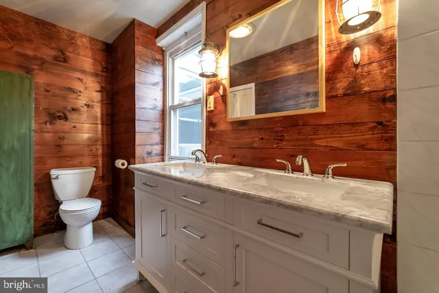 a bathroom with a granite countertop sink a toilet and a mirror