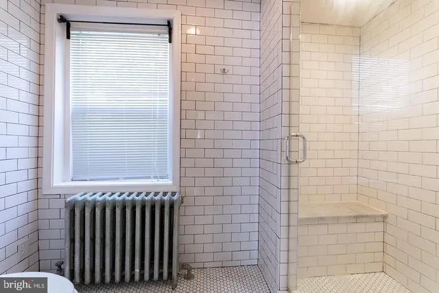 a bathroom with a window and a shower