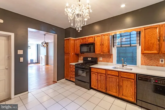 a kitchen with stainless steel appliances granite countertop a stove top oven a sink dishwasher and a refrigerator with wooden floor