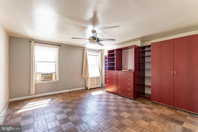 a view of an empty room with window and cabinet