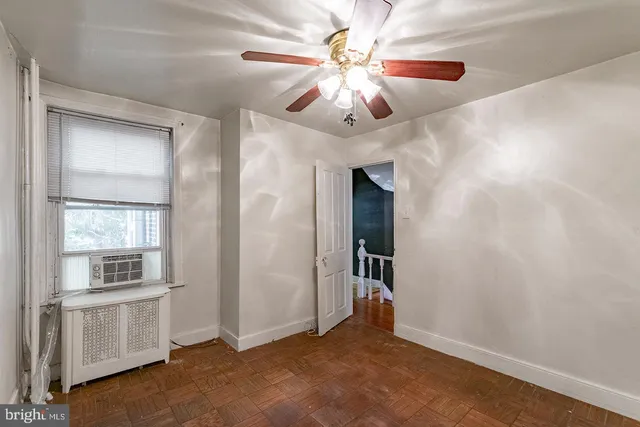 an empty room with windows and fan