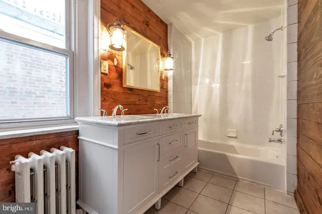 a bathroom with a tub sink and mirror