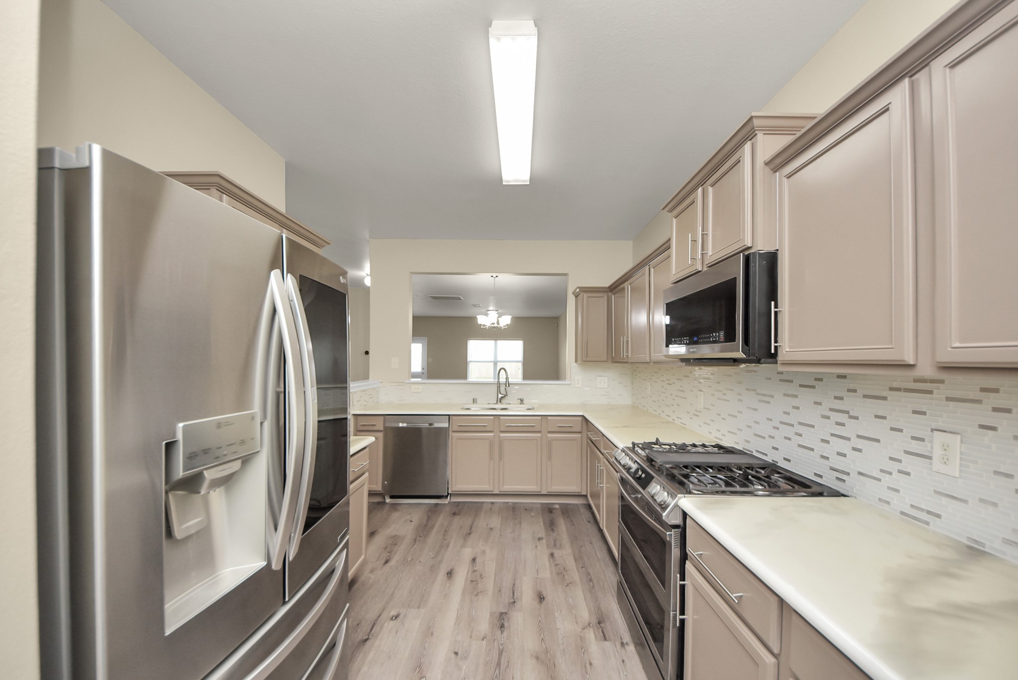 1855 Garnet Breeze Drive Rosharon, TX 77583 - Photo 2 of 38 a kitchen with a sink stove and refrigerator