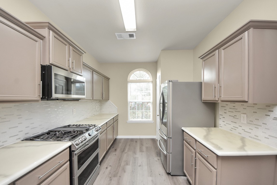 1855 Garnet Breeze Drive Rosharon, TX 77583 - Photo 9 of 38 a kitchen with stainless steel appliances granite countertop a sink stove and refrigerator