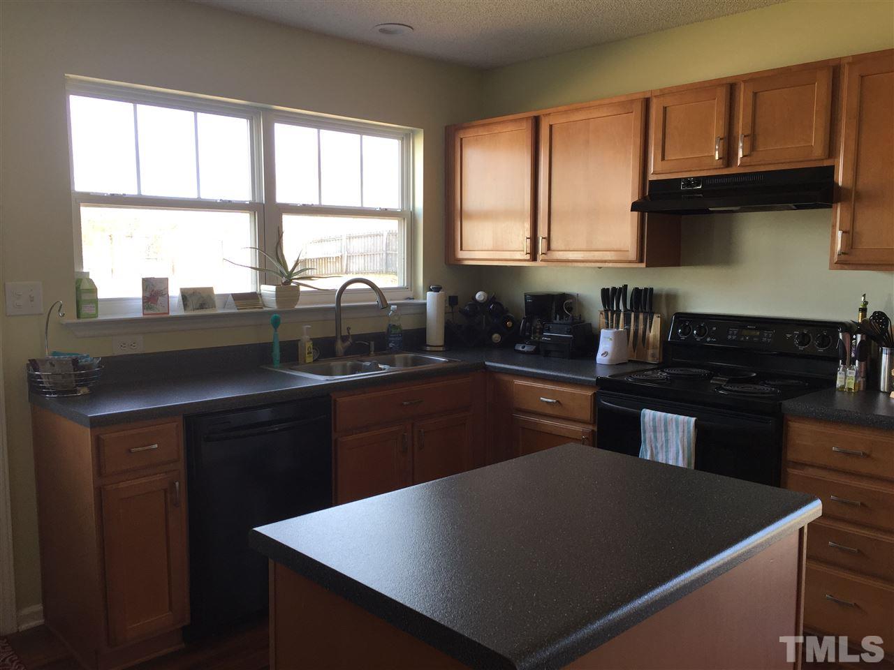 3613 Deering Drive Raleigh, NC 27616 - Photo 10 of 20 a kitchen with a sink a stove and black cabinets