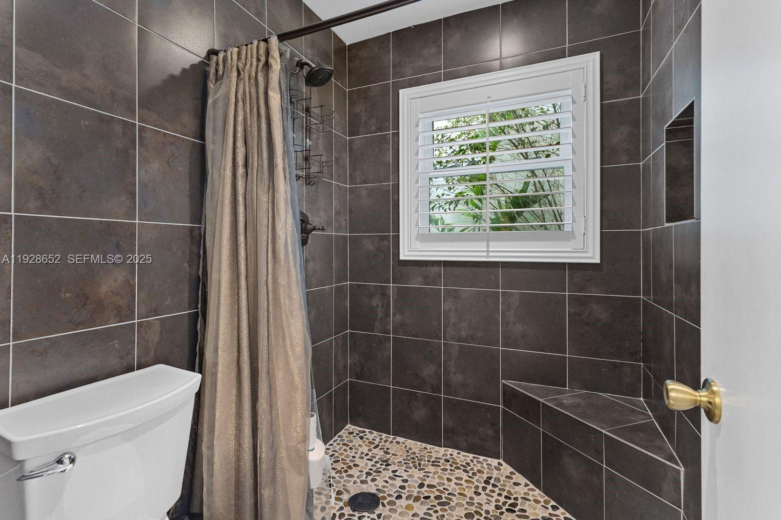 9871 Southwest 58th Court Cooper City, FL 33328 - Photo 14 of 54 a bathroom with a shower a toilet and a sink