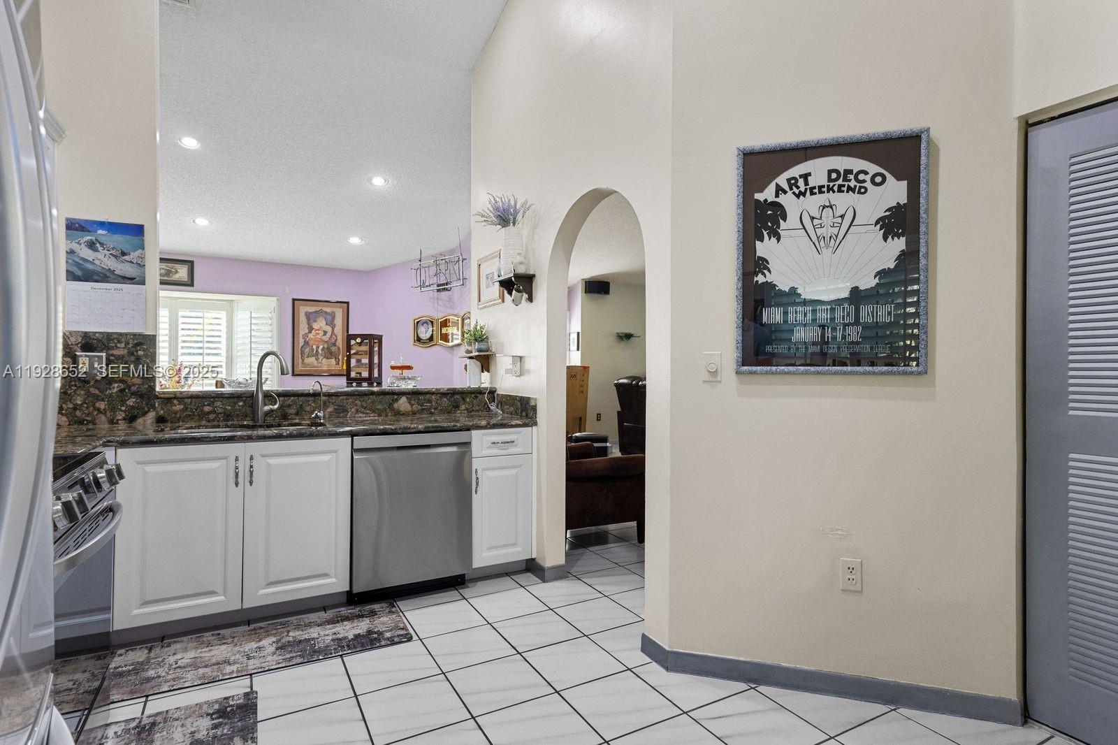 9871 Southwest 58th Court Cooper City, FL 33328 - Photo 17 of 54 a kitchen with stainless steel appliances granite countertop a refrigerator and a sink