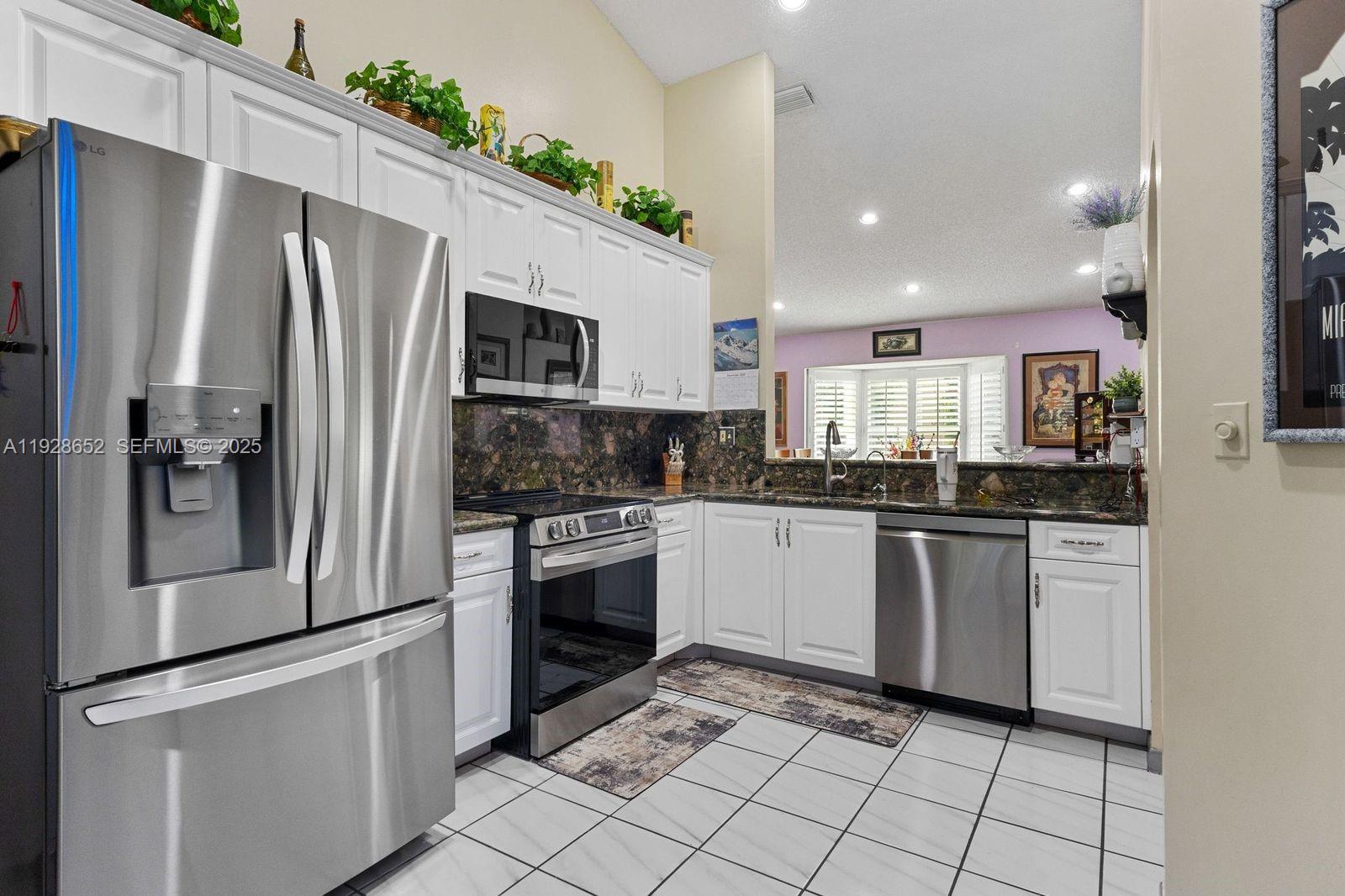 9871 Southwest 58th Court Cooper City, FL 33328 - Photo 18 of 54 a kitchen with stainless steel appliances a refrigerator sink and microwave