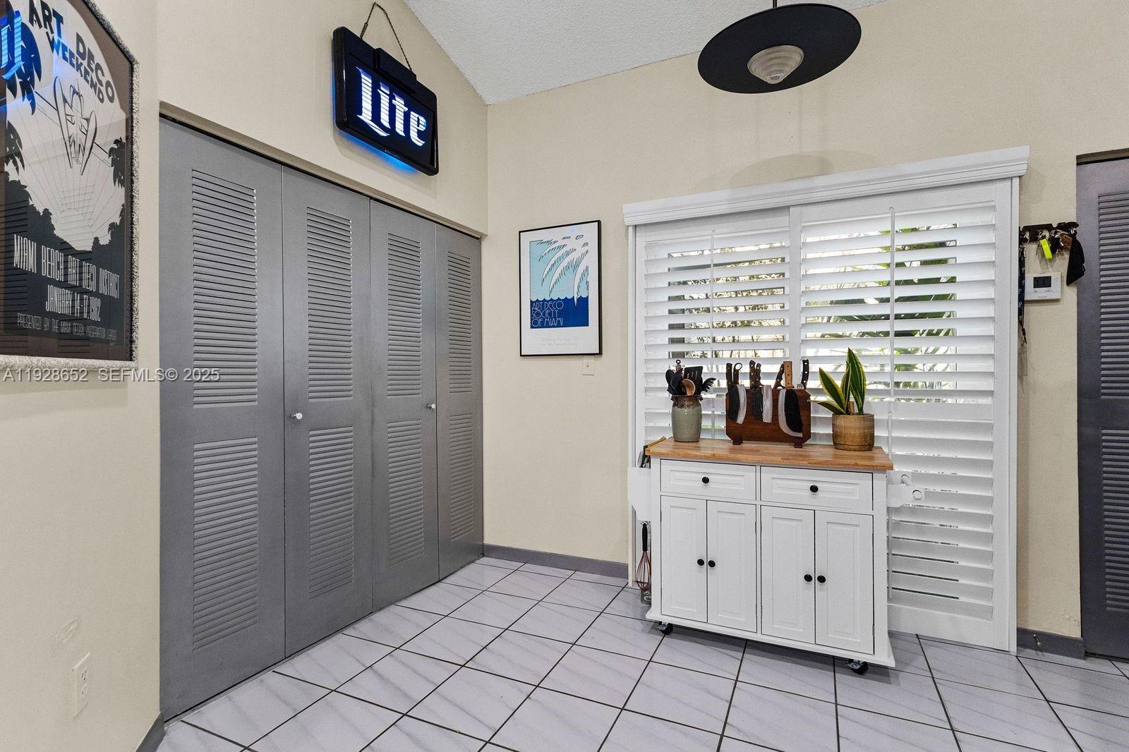 9871 Southwest 58th Court Cooper City, FL 33328 - Photo 19 of 54 a view of cabinets with wooden floor and windows