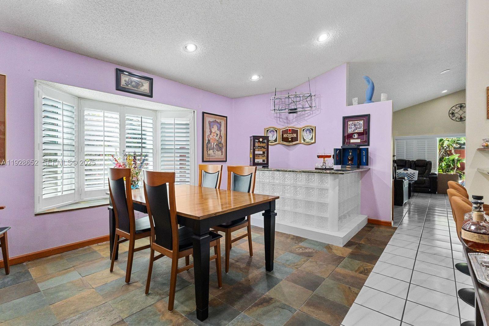 9871 Southwest 58th Court Cooper City, FL 33328 - Photo 22 of 54 a view of a dining room with furniture and a large window