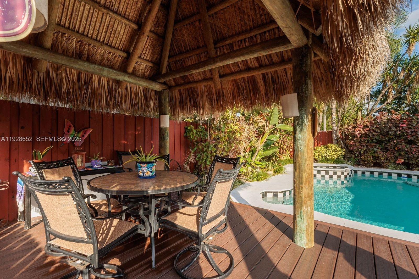 9871 Southwest 58th Court Cooper City, FL 33328 - Photo 39 of 54 a view of a patio with table and chairs with wooden floor and fence