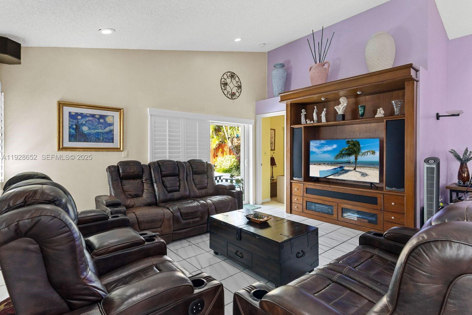 9871 Southwest 58th Court Cooper City, FL 33328 - Photo 9 of 54 a living room with furniture and a flat screen tv