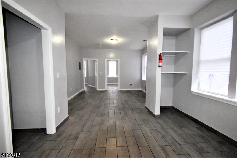 a view of a hallway with wooden floor and a window