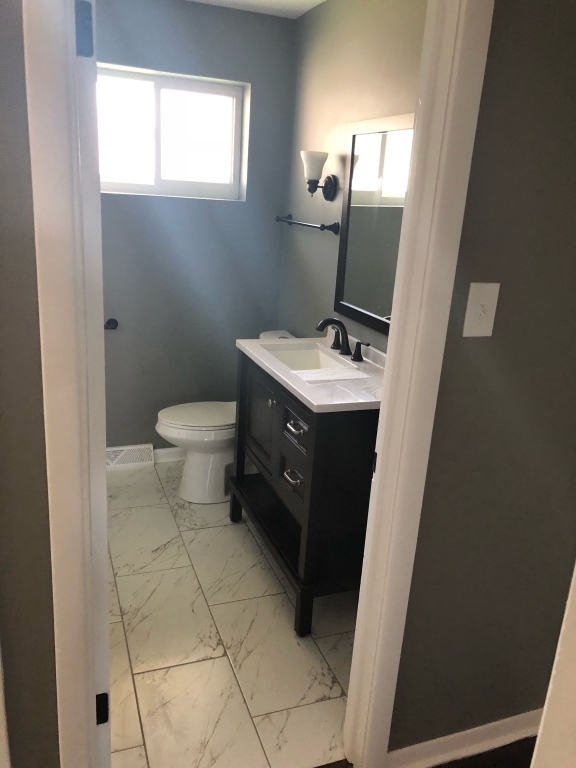248 Elmwood Drive West Chicago Heights, IL 60411 - Photo 3 of 4 a bathroom with a toilet sink and mirror