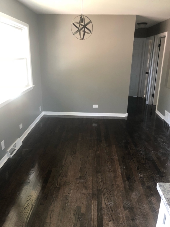 248 Elmwood Drive West Chicago Heights, IL 60411 - Photo 4 of 4 an empty room with wooden floor and windows
