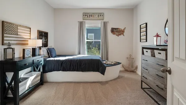 a bedroom with a bed and a dresser next to a window
