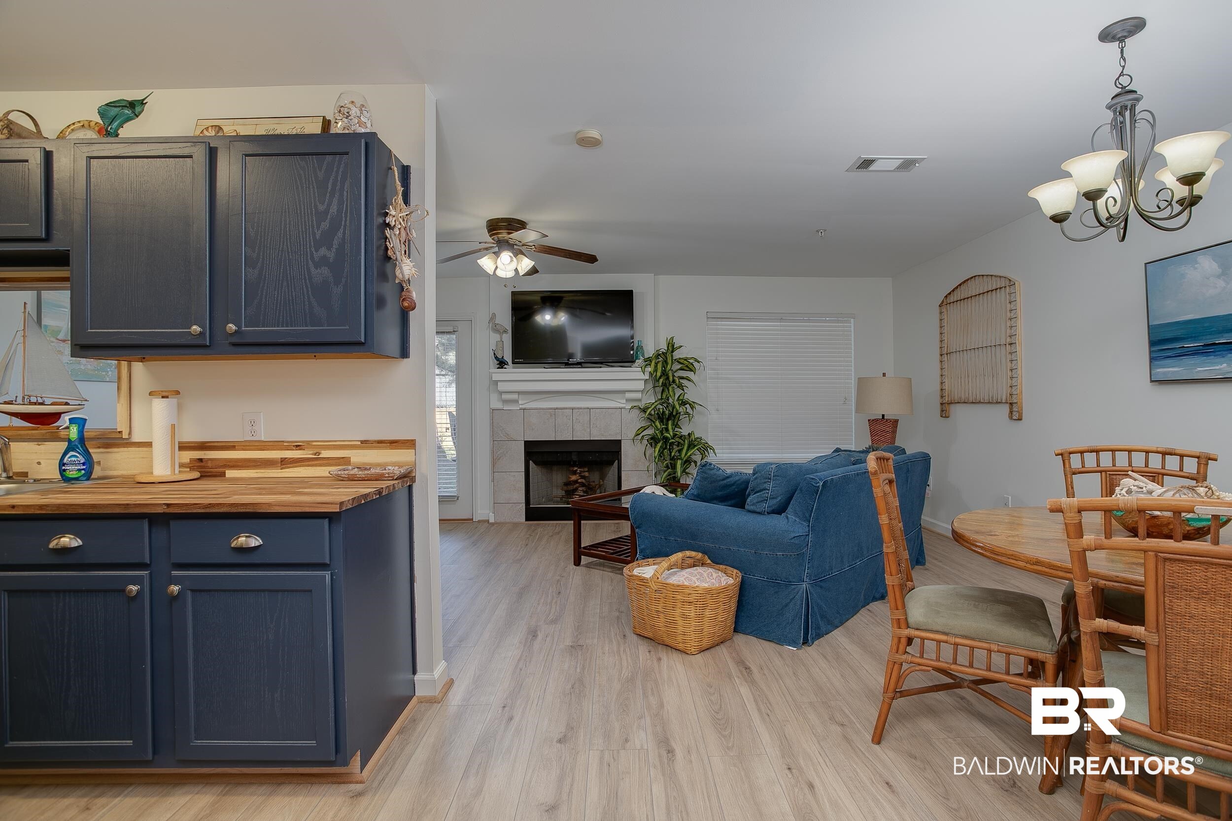 1517 Regency Road, Unit 33 Gulf Shores, AL 36542 - Photo 6 of 29 Living room with a tiled fireplace, ceiling fan with notable chandelier, light wood-style floors, and visible vents