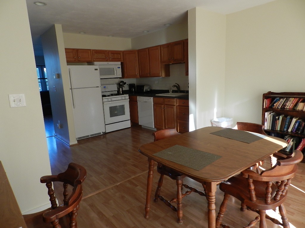 40 Wrentham Road, Unit 40 Worcester, MA 01602 - Photo 4 of 11 a kitchen with a table chairs refrigerator and microwave
