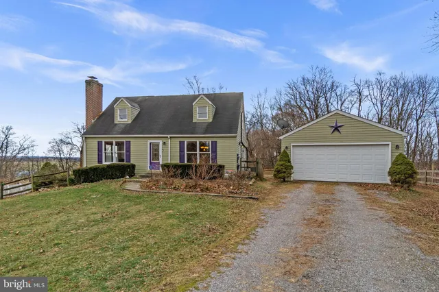a front view of house with yard and trees in the background