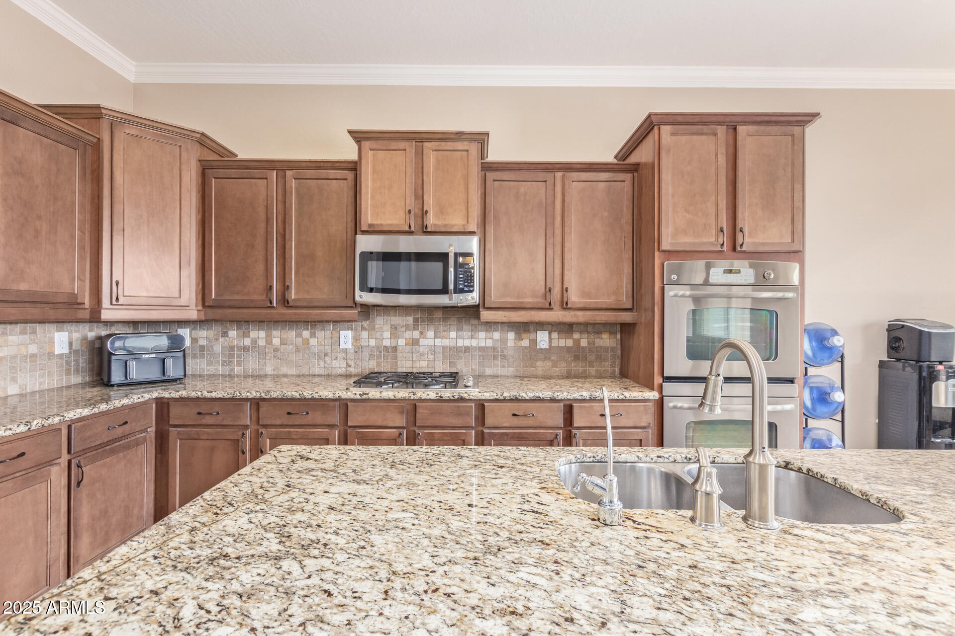 17743 West Verdin Road Goodyear, AZ 85338 - Photo 15 of 69 a kitchen with stainless steel appliances kitchen island granite countertop a refrigerator and cabinets