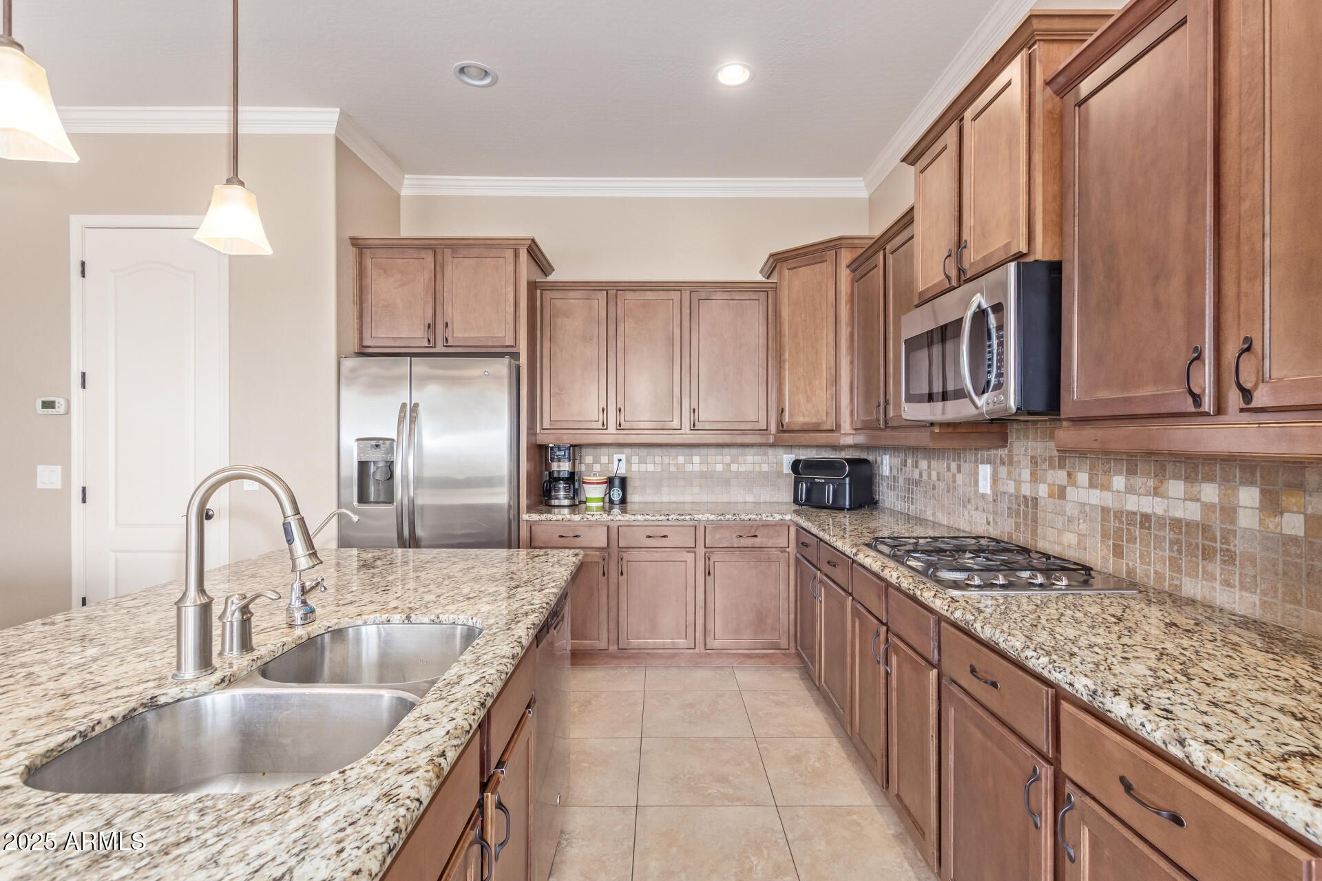17743 West Verdin Road Goodyear, AZ 85338 - Photo 17 of 69 a kitchen with kitchen island granite countertop a sink a counter space appliances and cabinets