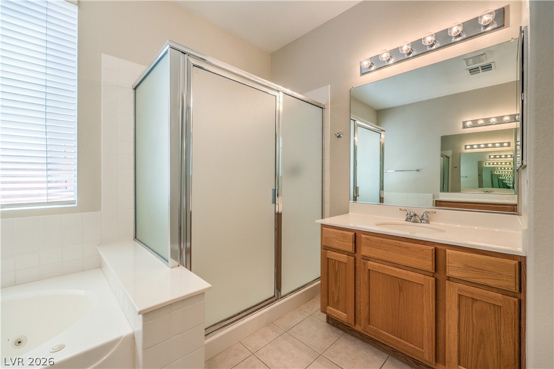 3713 Spring Shadow Road Las Vegas, NV 89129 - Photo 24 of 37 This primary bathroom provides both a comfortable bathtub and a separate shower, along with a spacious vanity and mirror.