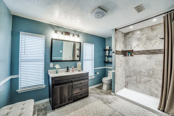 a bathroom with a double vanity sink mirror and shower