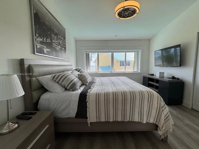 a bedroom with a bed and a flat tv screen on the dresser