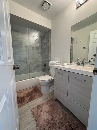 a bathroom with a double vanity sink toilet and shower