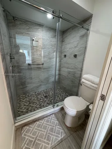 a bathroom with a toilet and a shower