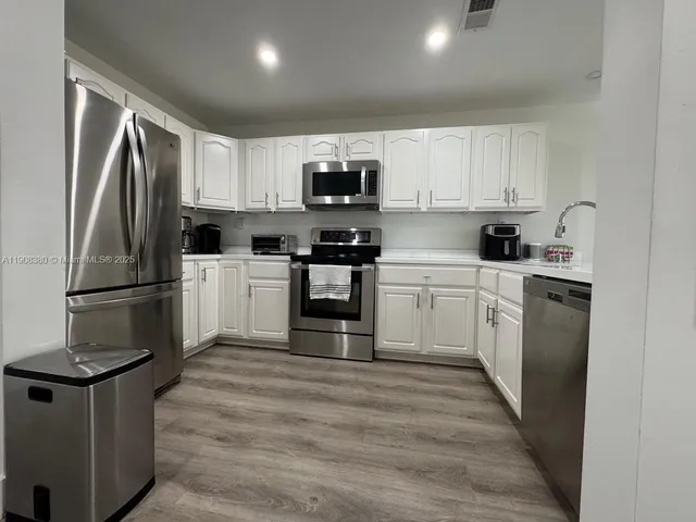 a kitchen with stainless steel appliances granite countertop a stove a sink and a refrigerator