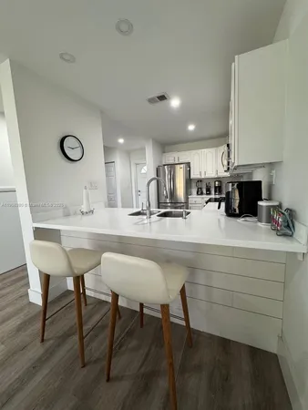 a kitchen with a table chairs sink and cabinets
