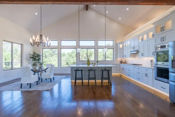 a kitchen with a sink a counter top space and living room view