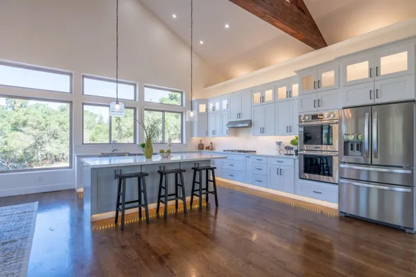 a kitchen with stainless steel appliances granite countertop a sink a stove and cabinets
