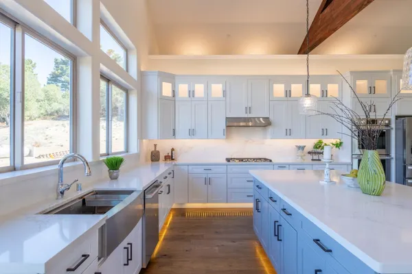 a kitchen with a stove a sink and a wooden floors