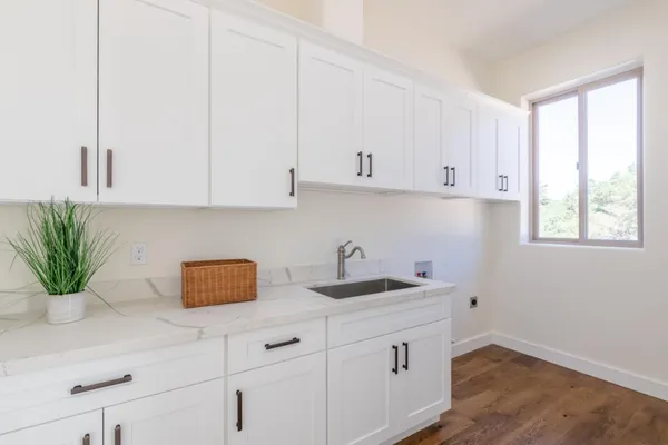 a kitchen with a sink white cabinets and white appliances