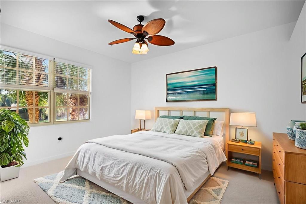 8581 Via Garibaldi Circle, Unit 201 Estero, FL 33928 - Photo 19 of 42 a bedroom with a bed and a chandelier