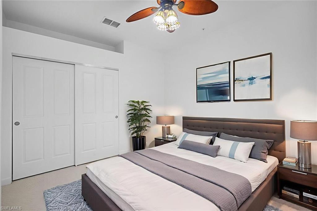 8581 Via Garibaldi Circle, Unit 201 Estero, FL 33928 - Photo 20 of 42 a bedroom with a bed and a painting on the wall