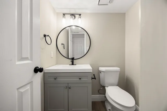 a bathroom with a toilet a sink and a mirror