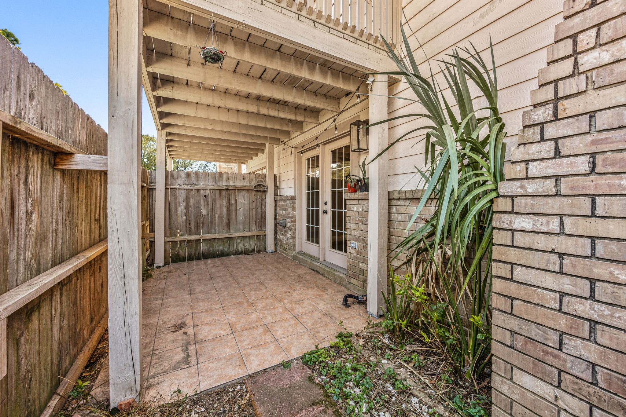 16919 Chapel Pines Drive, Unit 128 Spring, TX 77379 - Photo 19 of 24 This covered patio and side yard create a versatile outdoor space, offering a quiet setting for relaxing, entertaining, or enjoying low-maintenance outdoor living.