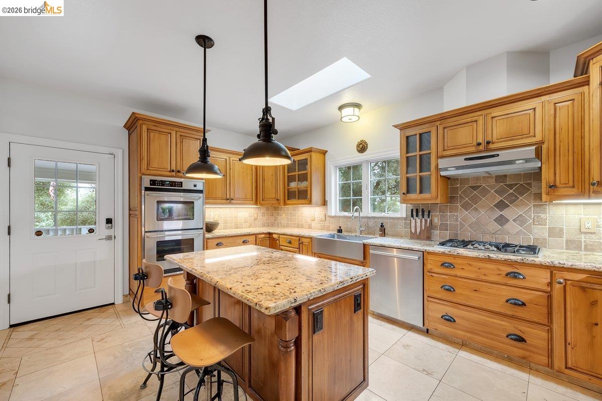 21950 Lyons Bald Mountain Road Sonora, CA 95370 - Photo 16 of 76 a kitchen with stainless steel appliances granite countertop a stove a sink dishwasher and cabinets with wooden floor