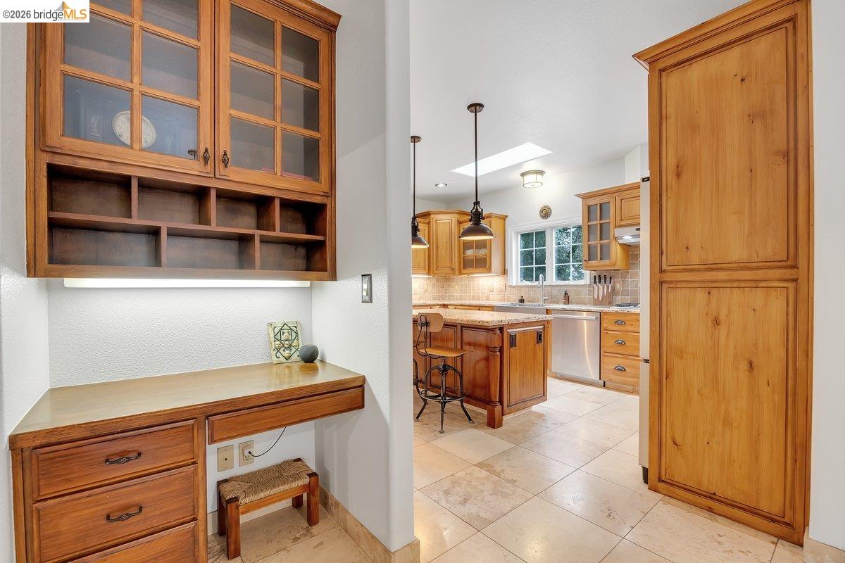 21950 Lyons Bald Mountain Road Sonora, CA 95370 - Photo 24 of 76 Built-in wood-finish desk with task lighting and upper cabinetry featuring glass-front doors