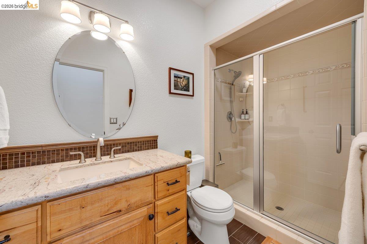 21950 Lyons Bald Mountain Road Sonora, CA 95370 - Photo 35 of 76 a bathroom with a granite countertop sink a toilet and shower