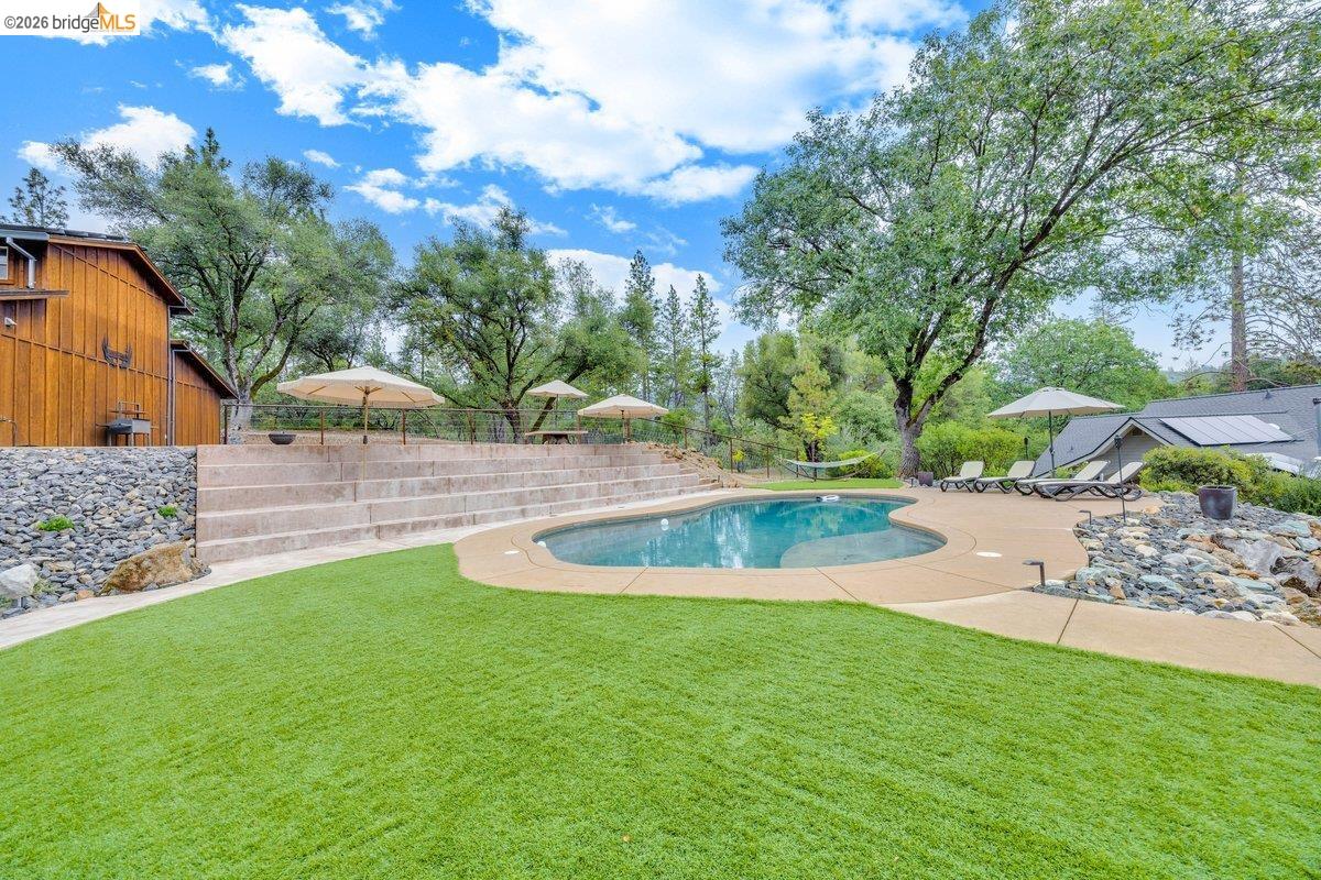 21950 Lyons Bald Mountain Road Sonora, CA 95370 - Photo 60 of 76 a view of a swimming pool with a yard