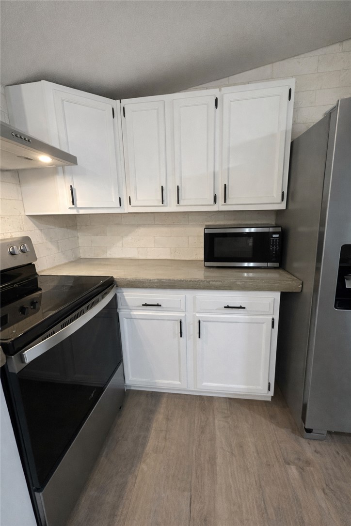 7031 Red Rock Road Franklin, TX 77856 - Photo 7 of 17 a kitchen with white cabinets and stainless steel appliances