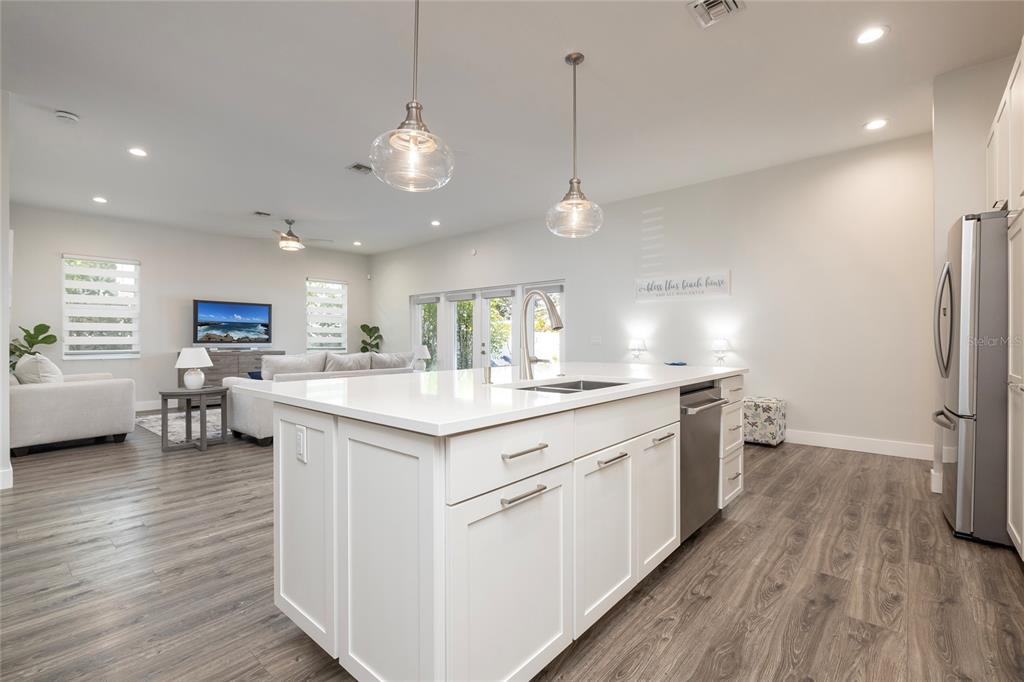 416 Indiana Avenue Crystal Beach, FL 34683 - Photo 11 of 60 a kitchen with stainless steel appliances granite countertop a sink stove and wooden floor