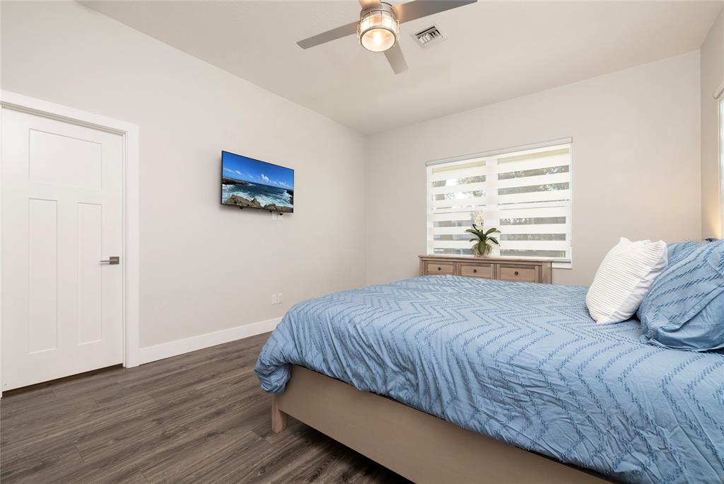 416 Indiana Avenue Crystal Beach, FL 34683 - Photo 14 of 60 a bedroom with a bed and wooden floor