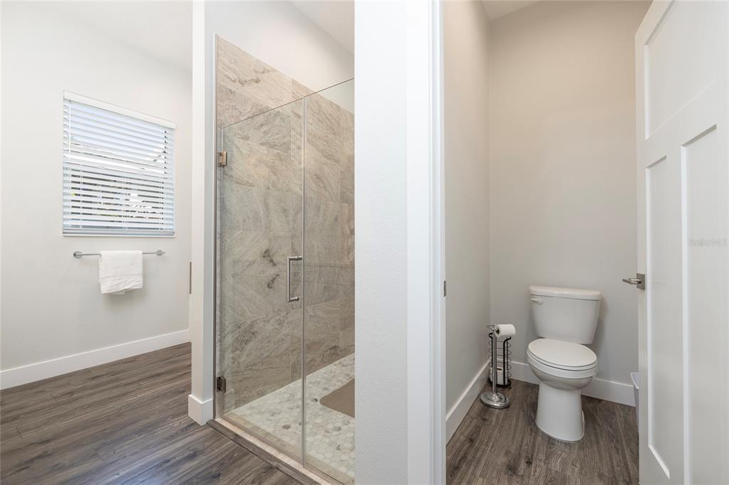416 Indiana Avenue Crystal Beach, FL 34683 - Photo 16 of 60 a bathroom with a granite countertop toilet and a shower