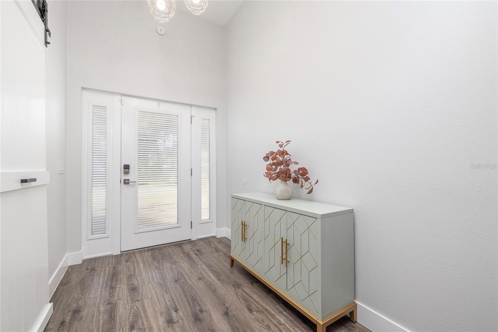 416 Indiana Avenue Crystal Beach, FL 34683 - Photo 4 of 60 a view of a hallway to a livingroom with wooden floor and entryway
